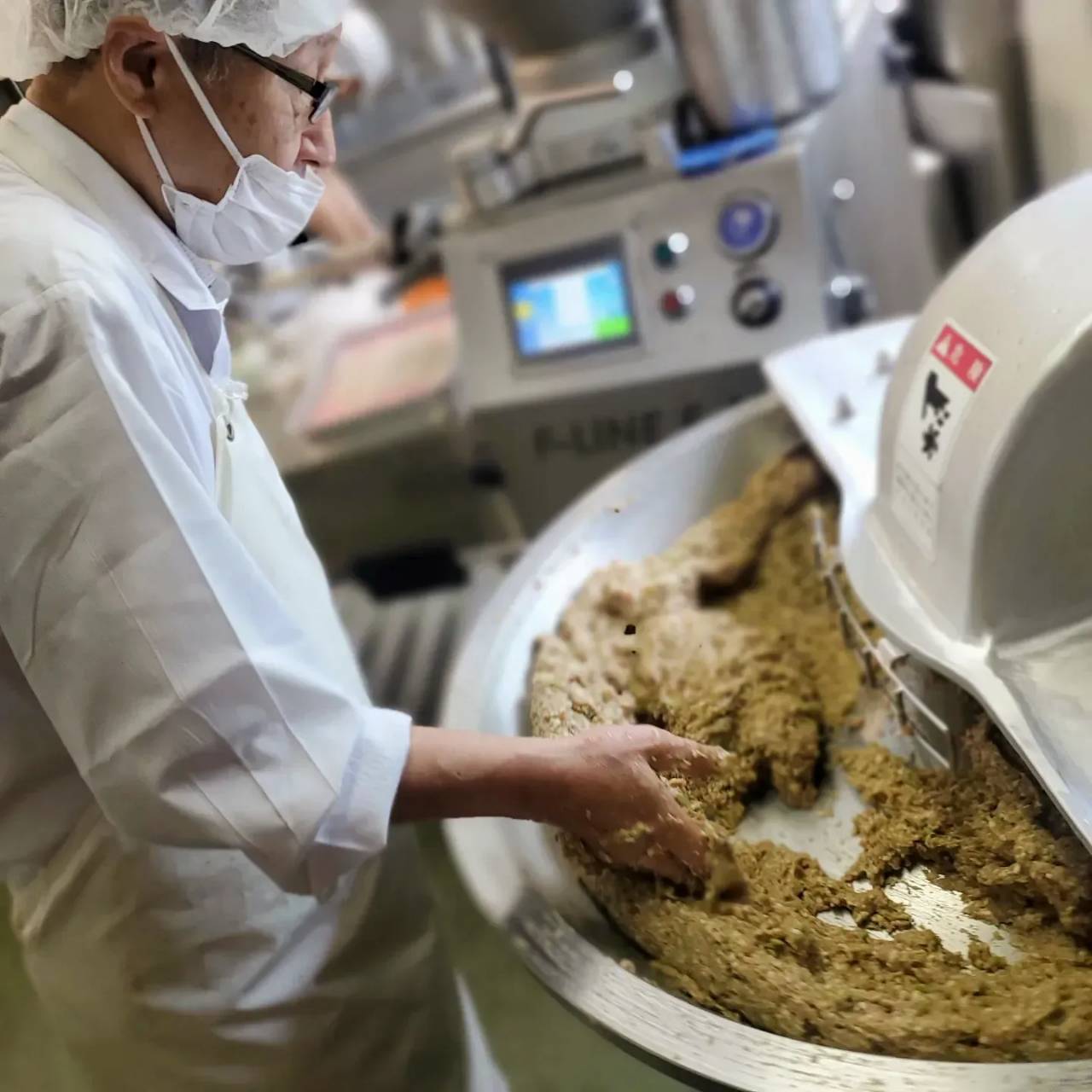 工房でミキサーの前に立ち、作業するじぃじ