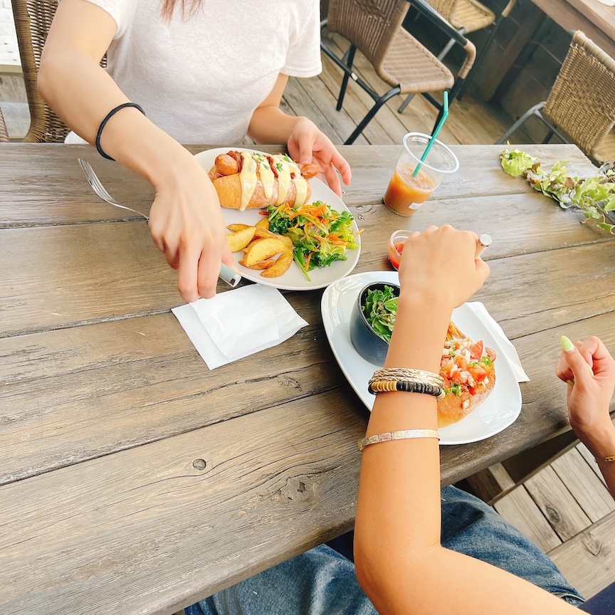 AOのテラス席でホットドッグのプレートを楽しむ食事風景